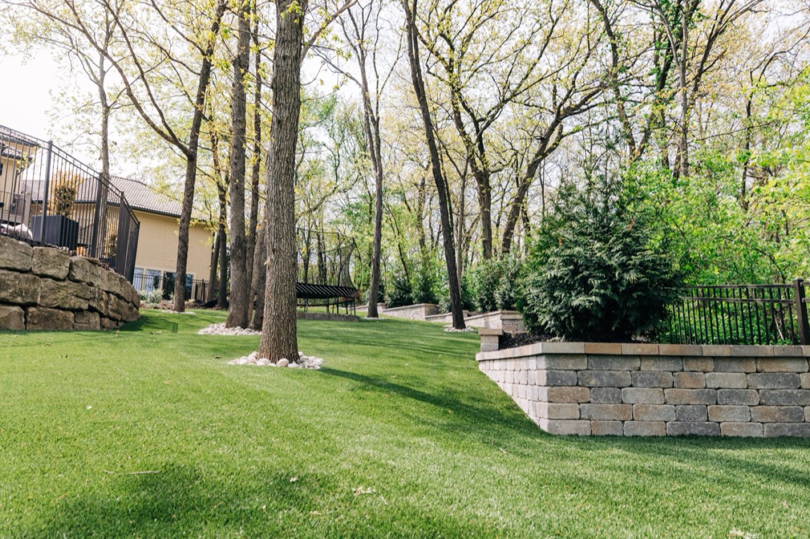 LandScapes premium residential synthetic turf landscape with stone hardscape and mature trees